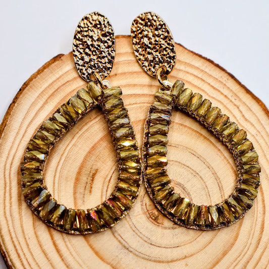 Teardrop-shaped earrings feature delicately woven golden accents, reminiscent of cascading petals.
