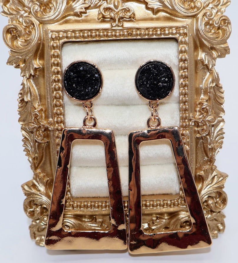 Gold and black earrings feature a unique geometric design with a hammered gold finish.