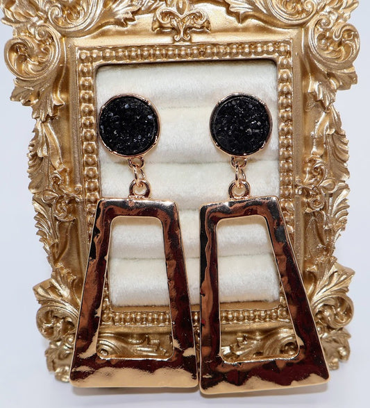Gold and black earrings feature a unique geometric design with a hammered gold finish.