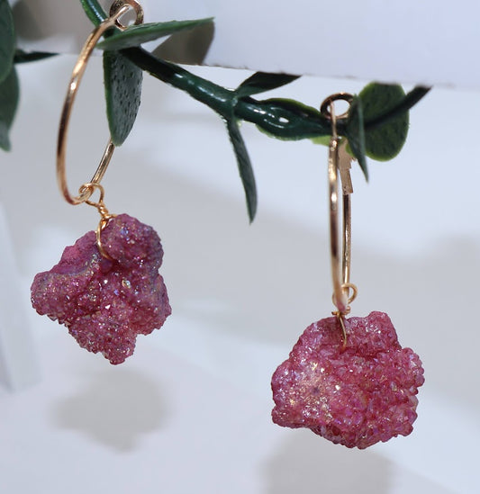 Pink stone earrings on gold hoops.