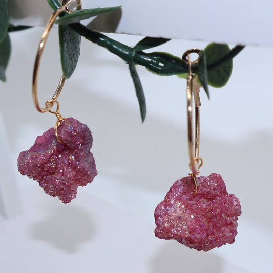 Pink stone earrings on gold hoops.
