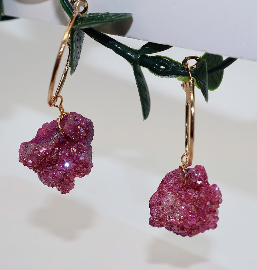 Pink stone earrings with gold hooks on a white background