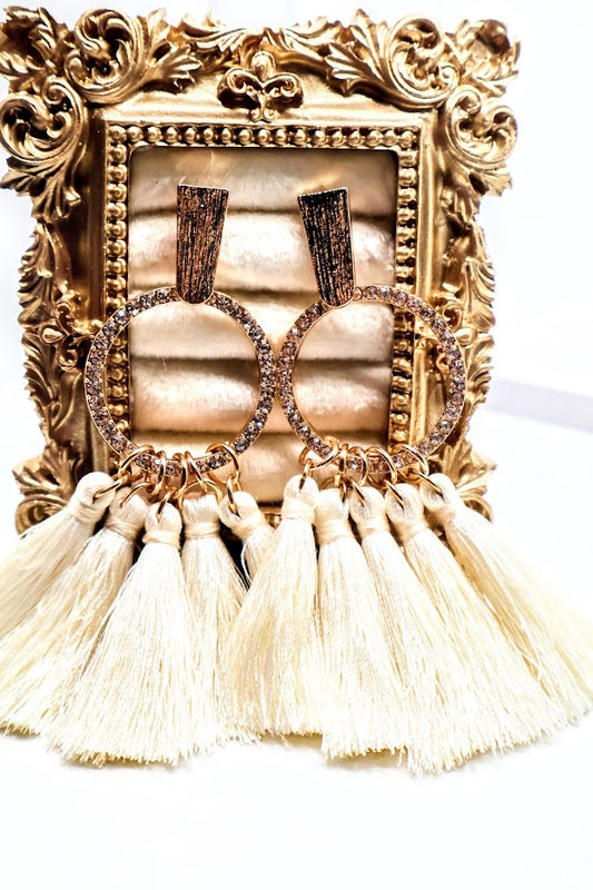 Ivory Tassel Earrings. Featuring soft ivory tassels cascading from a gold-textured hoop adorned with delicate beading.