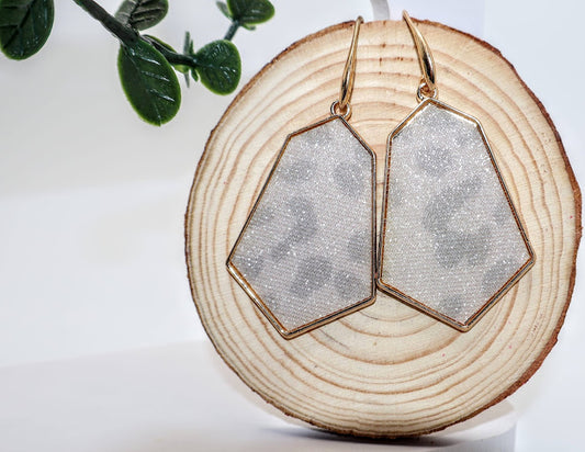 Geometric earrings featuring a chic pentagon shape framed in radiant gold, these earrings showcase a subtle leopard print design,