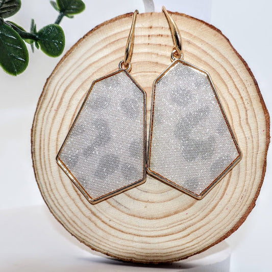 Geometric earrings featuring a chic pentagon shape framed in radiant gold, these earrings showcase a subtle leopard print design,