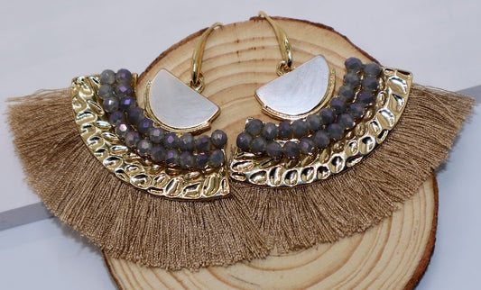 Earrings featuring soft gold fringe, shimmering metallic accents, and a chic geometric design.