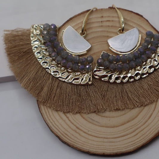 Earrings with gold and silver design on a wooden block