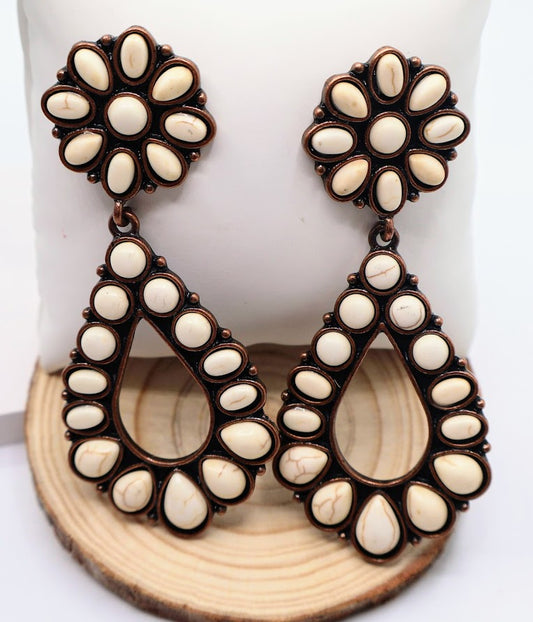 Teardrop-shaped earrings feature a beautiful combination of vintage-inspired detailing and modern chic, adorned with creamy white stones.