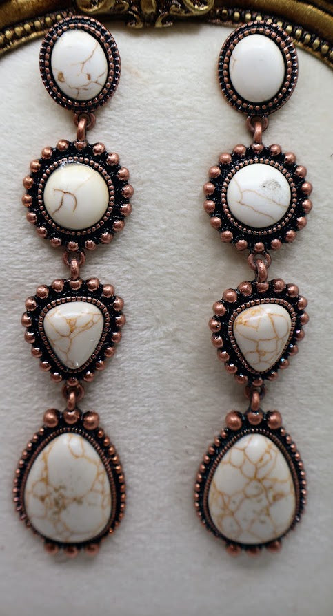 Pair of earrings with white stone and copper-like frame.