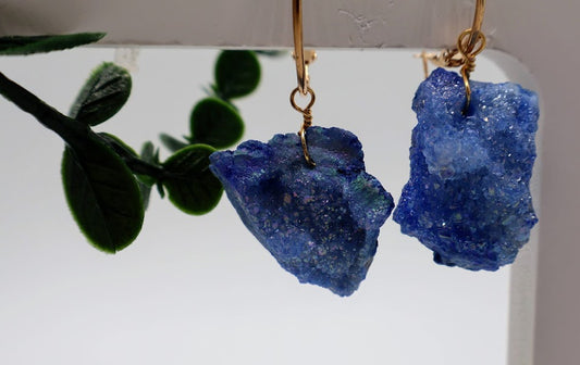 Stone earrings feature a stunning duo of man-made geode-inspired charms, sparkling with a mesmerizing blend of blue hues.