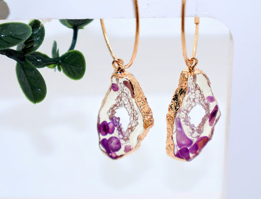 Gold-framed earrings with clear stone shape purple floral incorporated.
