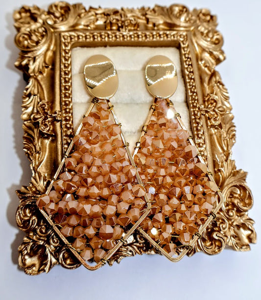 Pair of golden beaded earrings feature a sophisticated geometric design adorned with radiant golden bead.