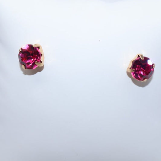 Pair of earrings with pink gemstones on a white cushion