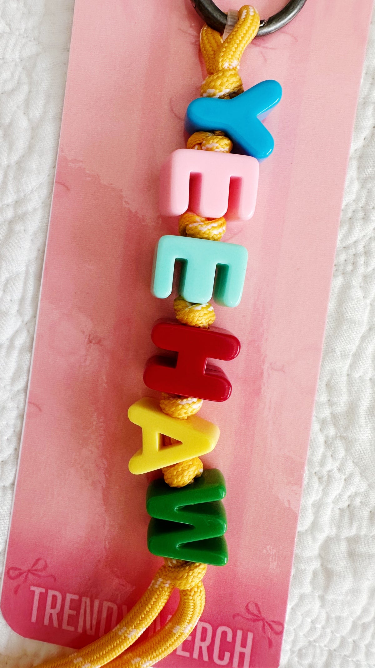 Full view of Yeehaw multicolor letter bag charm with yellow cord and gunmetal-tone clip ring
