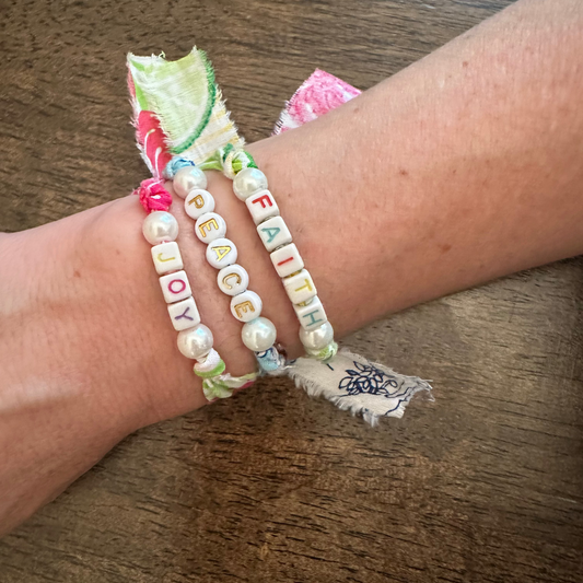 Wrist with colorful bracelets on a wooden surface