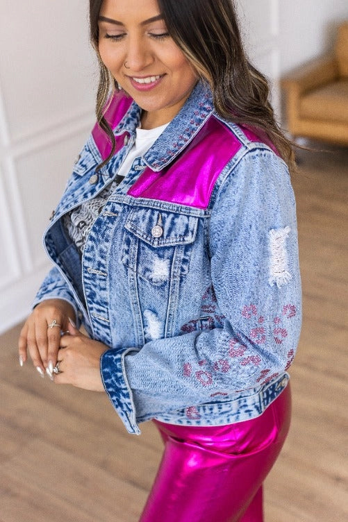 Denim Jacket is a striking blend of classic denim and glamorous details. Featuring a fitted silhouette, distressed touches, vibrant satin panels, and jeweled accents.