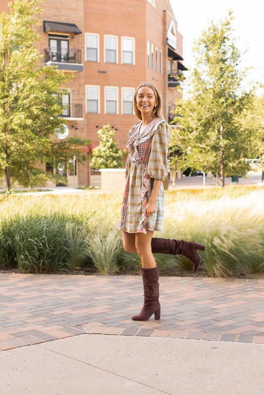 Plaid Ruffle Wrap Dress. Featuring a mix of soft plaid patterns, a flattering wrap design, and ruffled details along the neckline and hem.