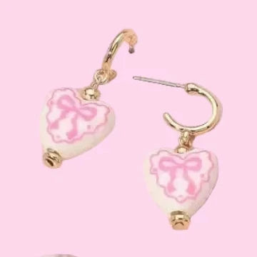 Heart-shaped earrings with pink marbled design on a pink background