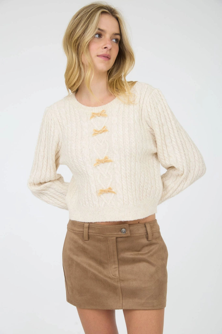 Cream Velvet Bow Cable Knit Sweater is a cozy and stylish addition to your wardrobe. Featuring a classic cable knit pattern and a round crew neckline.