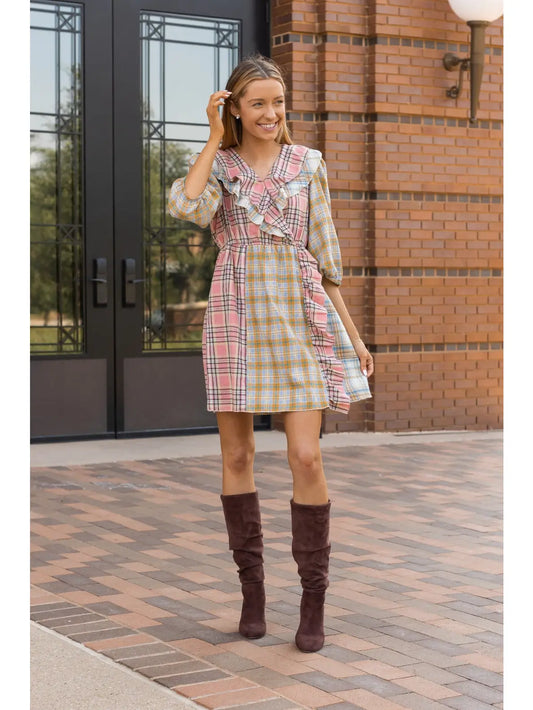 Plaid Ruffle Wrap Dress. Featuring a mix of soft plaid patterns, a flattering wrap design, and ruffled details along the neckline and hem.