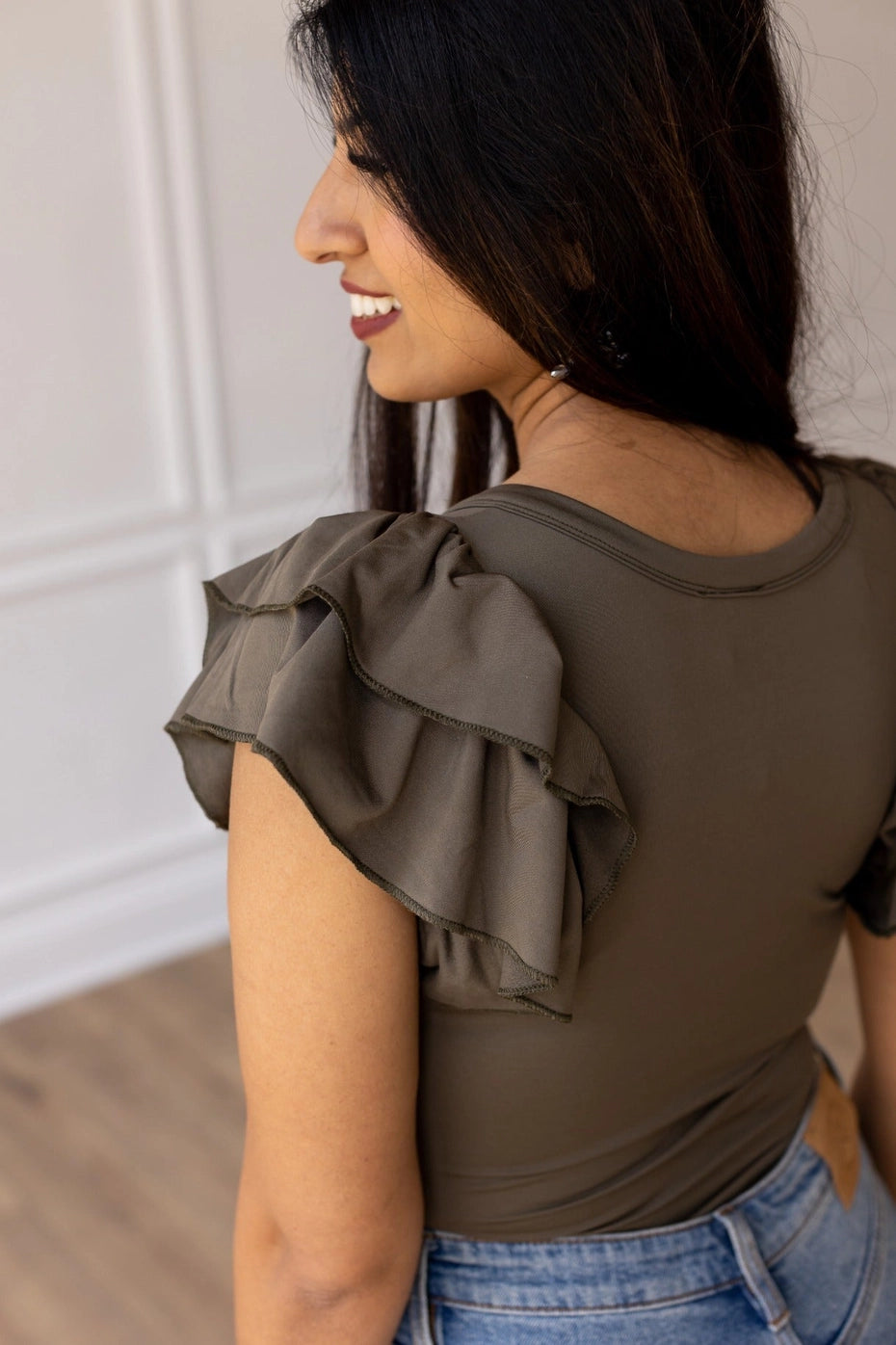 Olive Ruffle Sleeve Bodysuit combines elegance and practicality with its fitted design and charming ruffle sleeves.