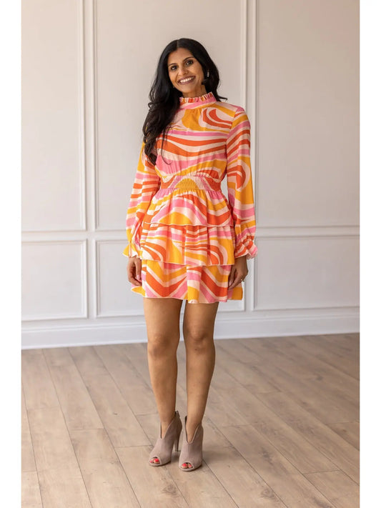 Swirl Print Dress is a vibrant and playful piece perfect for making a statement. Featuring a bold swirl pattern and a flattering smocked waist.