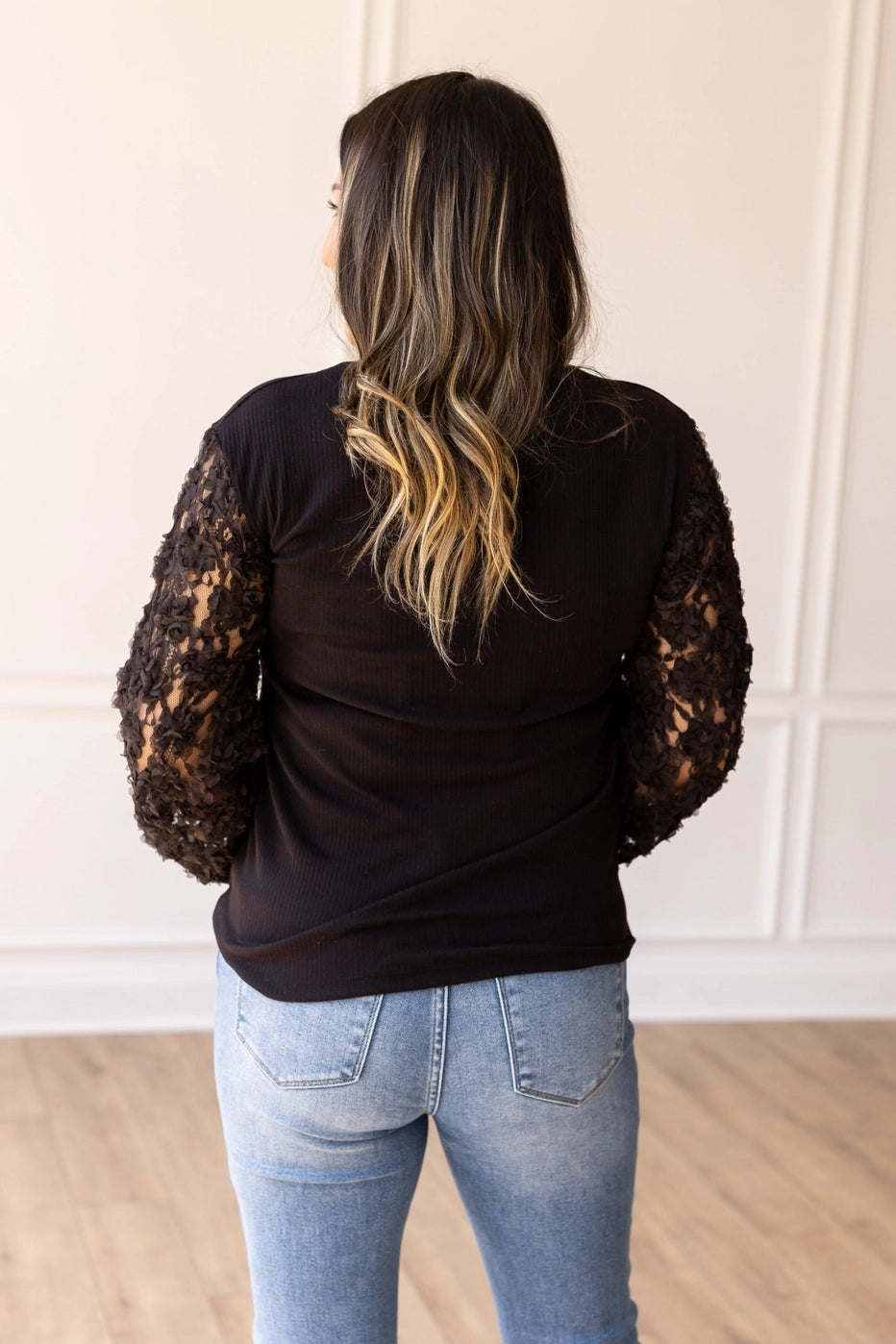 Black Lace Sleeve Top combines timeless elegance with modern charm. Featuring intricate lace sleeves and a classic crew neckline.