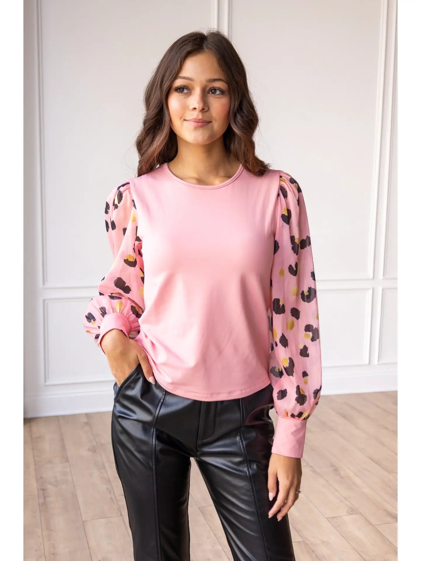 Pink Leopard Sleeve Top is a stylish blend of simplicity and boldness. Featuring sheer leopard-print puff sleeves and a sleek solid bodice.
