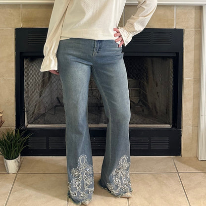 Woman standing in a living room with a fireplace and decorative items.