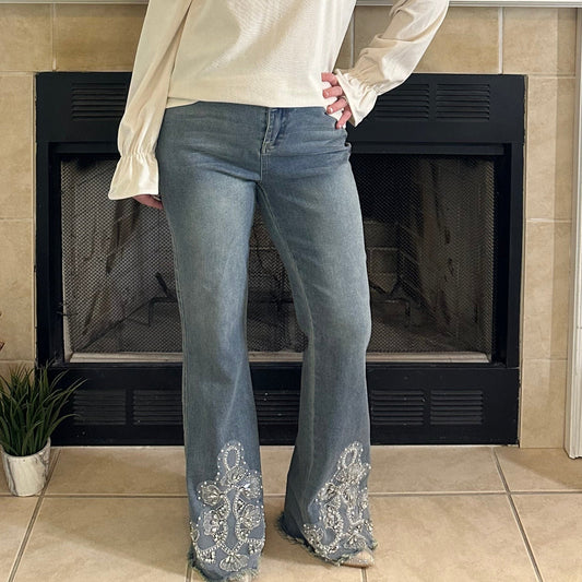 Woman standing in a living room with a fireplace and decorative items.