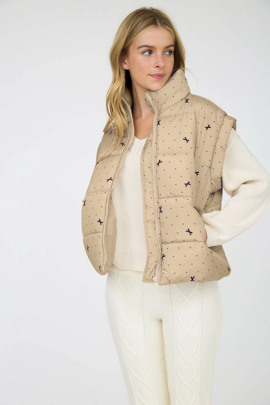 Light Khaki Polka Dot Bow Puffer Vest is a stylish and functional layering piece perfect for cooler weather. 
