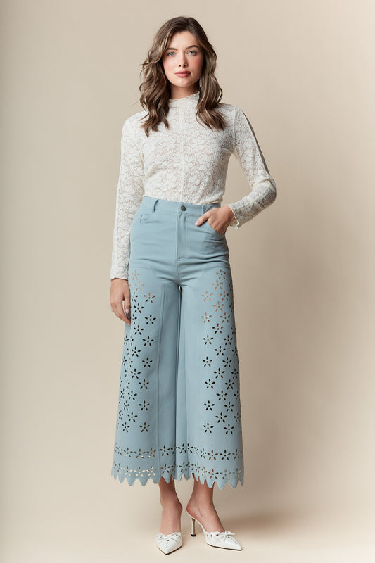  Wide-Leg Pants bring elegance and sophistication to any wardrobe. Designed with a wide-leg, high-waisted fit, these pants feature a delicate laser-cut floral pattern and scalloped hem.