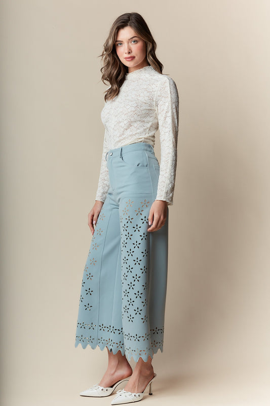  Wide-Leg Pants bring elegance and sophistication to any wardrobe. Designed with a wide-leg, high-waisted fit, these pants feature a delicate laser-cut floral pattern and scalloped hem.