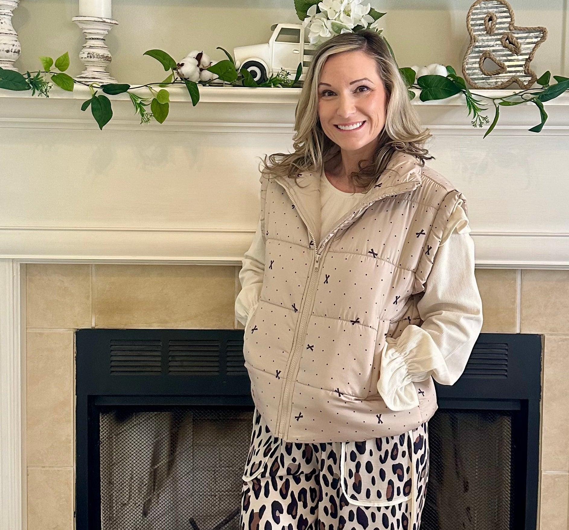 Woman standing in a living room with a decorated fireplace