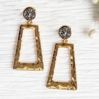 Gold earrings with geometric design on a white background