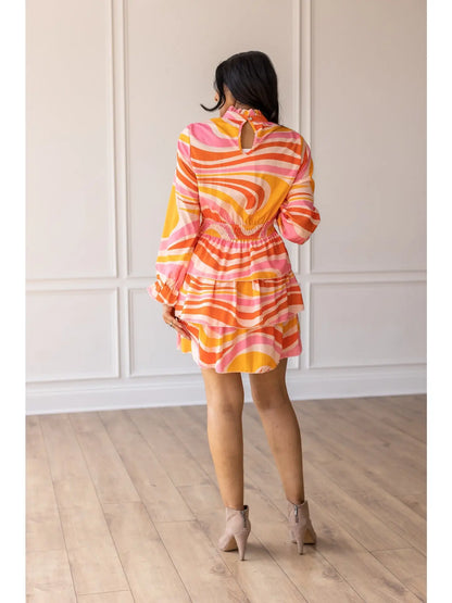  Swirl Print Dress is a vibrant and playful piece perfect for making a statement. Featuring a bold swirl pattern and a flattering smocked waist.