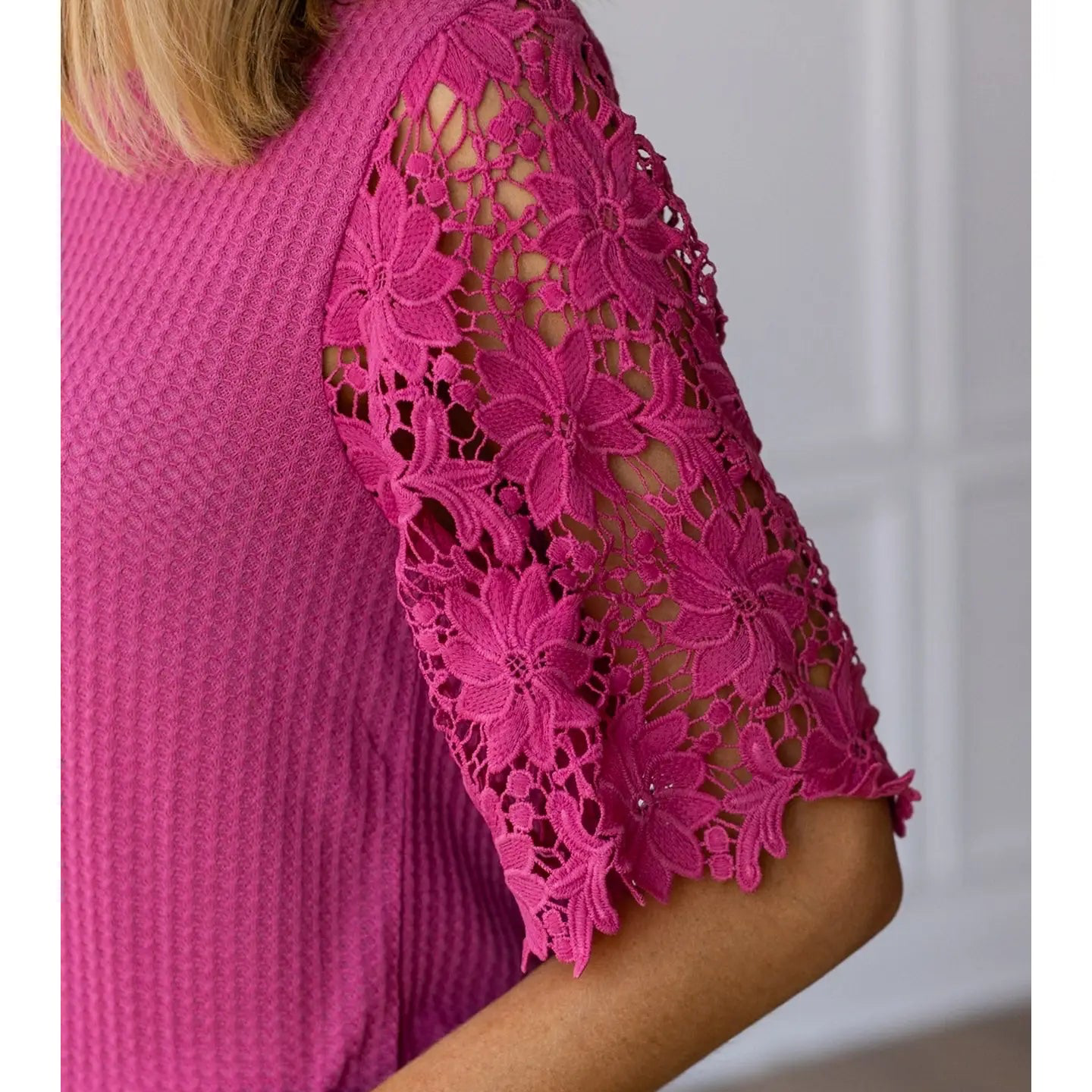 Close-up of a pink lace-trimmed top with a blurred background