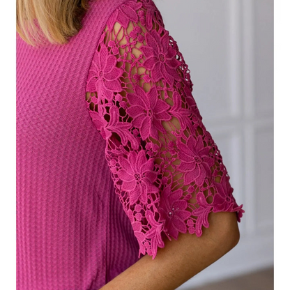 Close-up of a pink lace-trimmed top with a blurred background