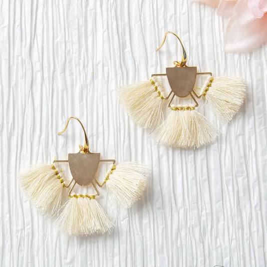 Pair of tassel earrings on a textured white background