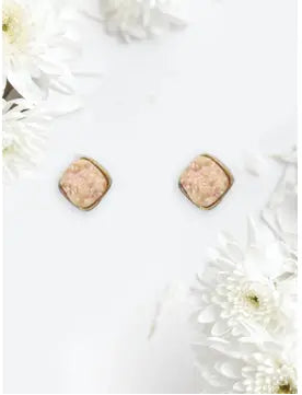 Pair of hexagonal earrings on a white surface with flowers
