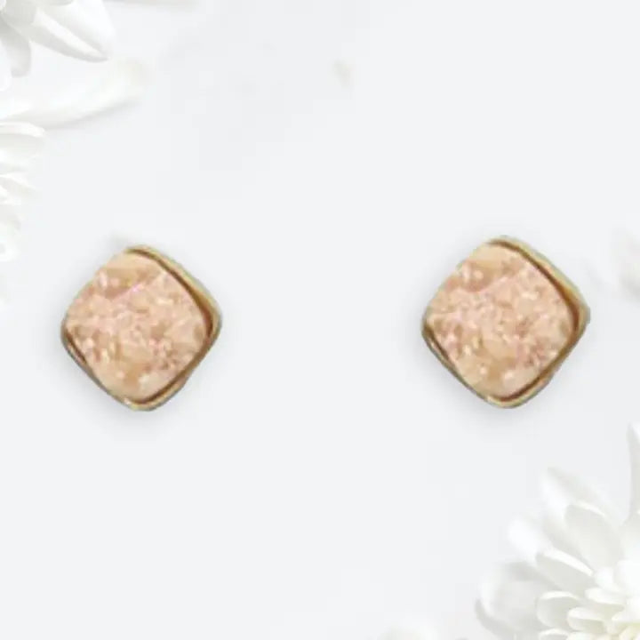 Pair of square-shaped earrings with a beige center and gold border on a white background.
