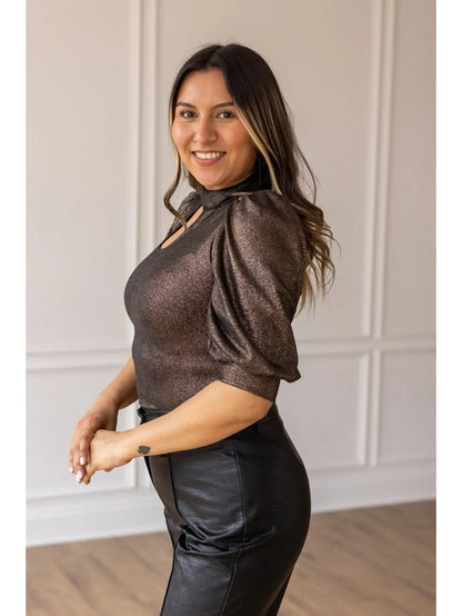  Metallic Puff Sleeve Bodysuit is a statement piece that brings elegance and glamour to any outfit. Featuring a shimmering metallic finish, puff sleeves, and a chic keyhole neckline.