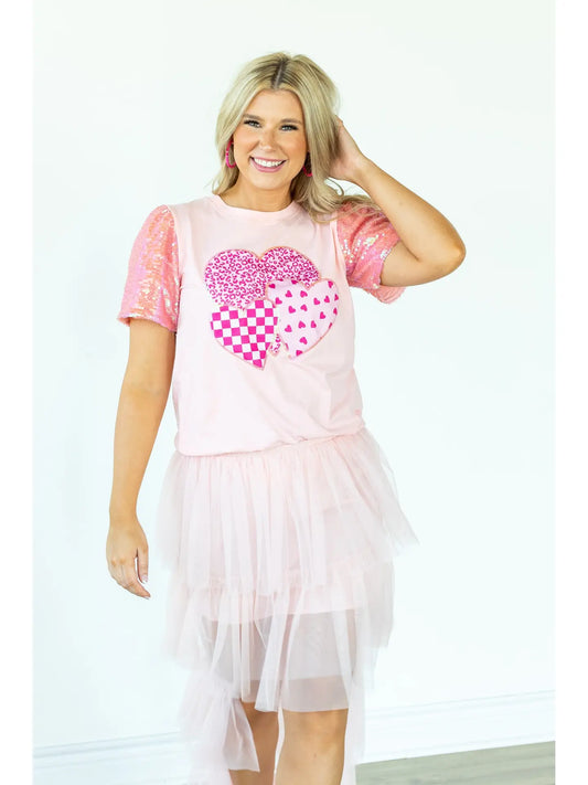 Sequin Sleeve Top is a playful and chic piece that stands out in any wardrobe. Featuring dazzling sequin-lined sleeves and a bold heart graphic.