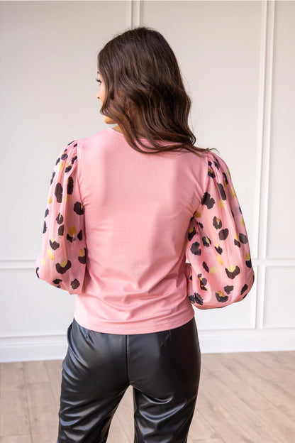 Pink Leopard Sleeve Top is a stylish blend of simplicity and boldness. Featuring sheer leopard-print puff sleeves and a sleek solid bodice.