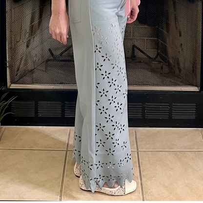 Person wearing a light-colored outfit with floral patterns in front of a fireplace.