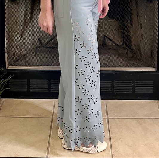 Person wearing a light-colored outfit with floral patterns in front of a fireplace.