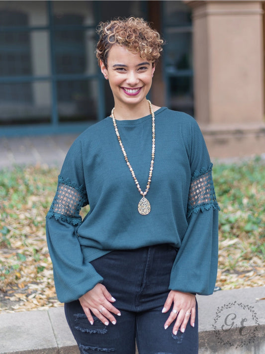 Teal Green Lace Accent Top is a perfect blend of comfort and style. Featuring delicate lace details on the sleeves and a relaxed fit.