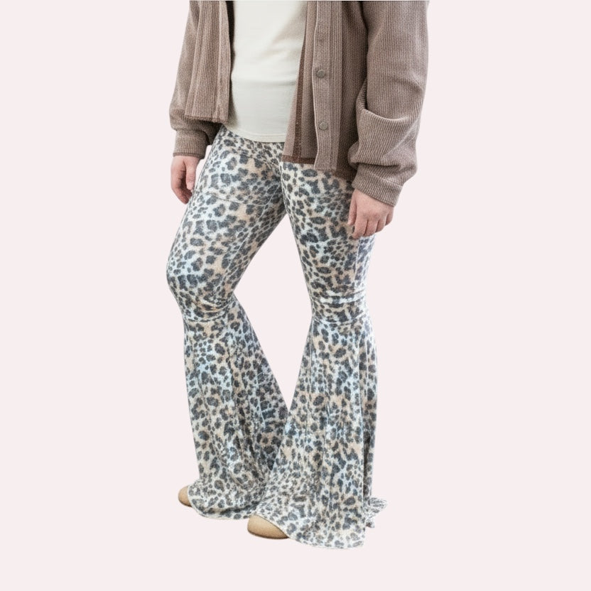 Person wearing leopard print flared pants against a plain background