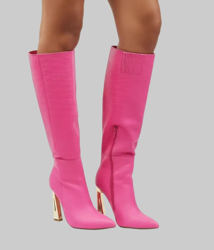  Croc Knee-High Boots are a bold statement piece designed to elevate any outfit. Featuring an eye-catching croc-embossed texture and a vibrant pink hue.