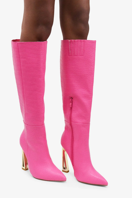 Croc Knee-High Boots are a bold statement piece designed to elevate any outfit. Featuring an eye-catching croc-embossed texture and a vibrant pink hue.